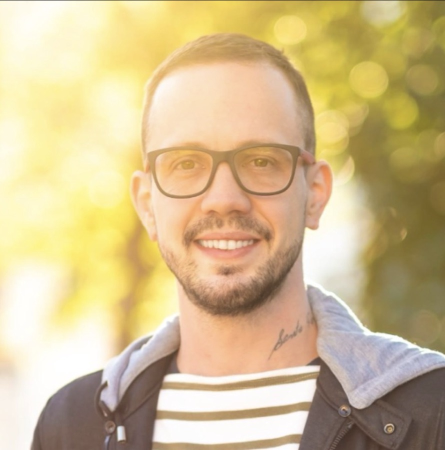 Retrato de Andre Raittz sorrindo, de óculos